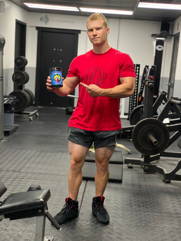 Natural bodybuilder and CEO of Polokus, Brandon Fandel, holding Primal Instinct Pre-Workout