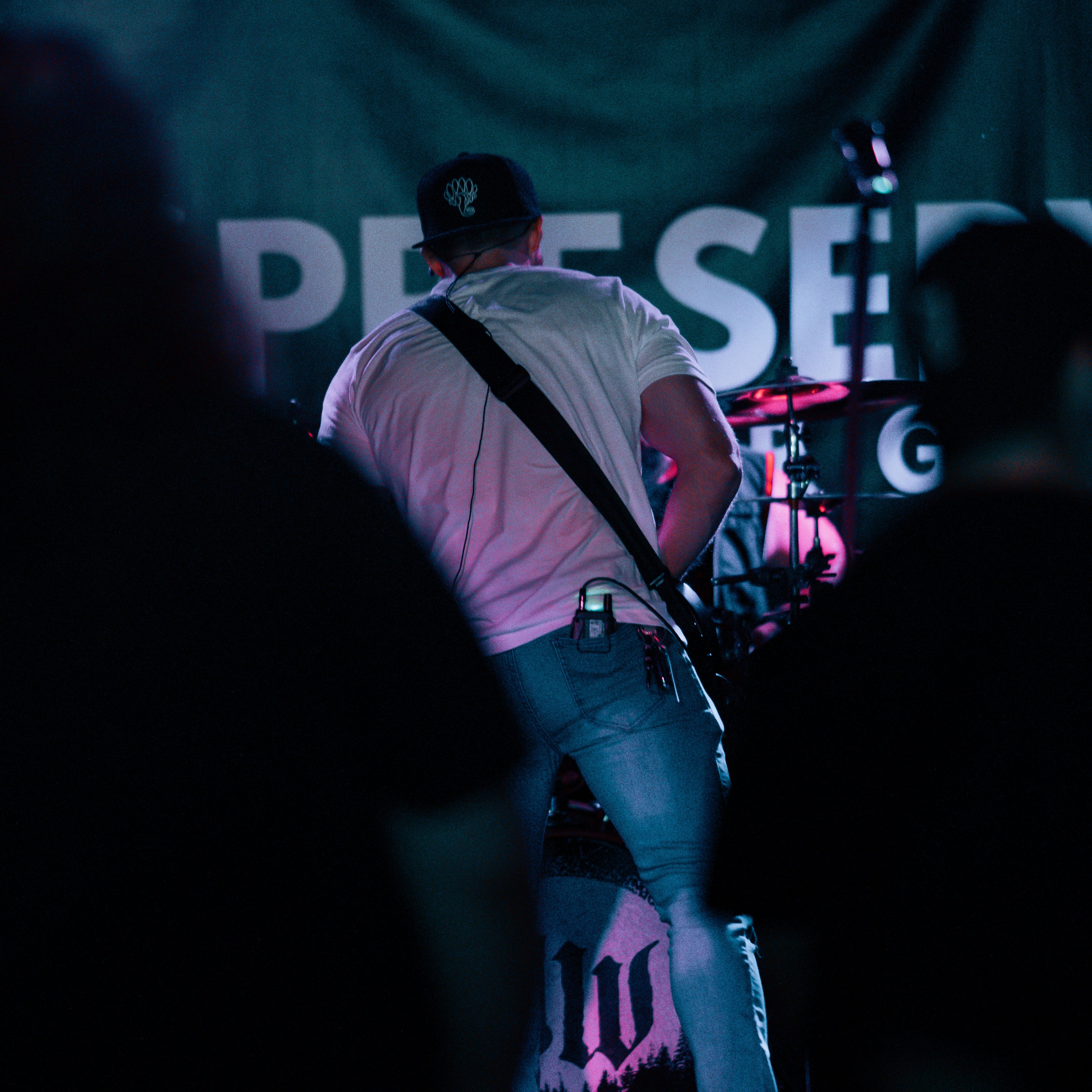 black snapback hat with polokus creature logo on stage performer musician